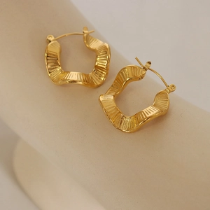 Golden irregular wave hoop earrings with textured stripe finish in stainless steel