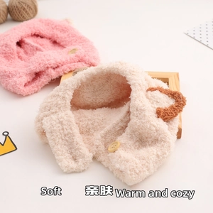 Close-up of plush baby earflap hats in pink and beige with cute brown round ears