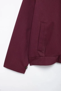 Detailed macro view of burgundy jacket cuff buttons and vertical pocket stitching detail