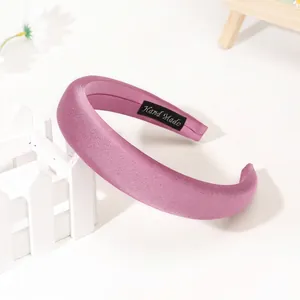 Detail of light purple satin headband showing smooth silk luster and handmade label