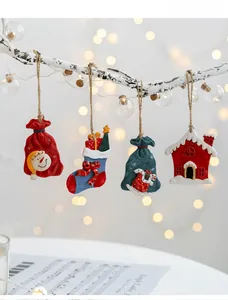 Set of four resin Christmas ornaments hanging on white branches with festive bokeh background