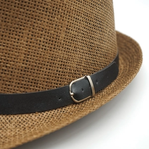 Close-up of brown straw hat weave with black leather band and silver buckle detail