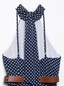 Detailed view of dark blue polka dot midi dress featuring halter neck and brown leather belt