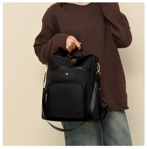 Detail of minimalist black oxford backpack featuring premium gold-tone metal hardware