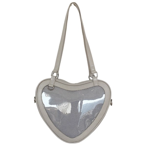 Detailed view of the heart-shaped Ita bag with a transparent PVC window and beige PU leather