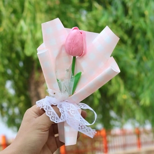 Single pink faux tulip bouquet with white lace ribbon in checkered gift wrapping