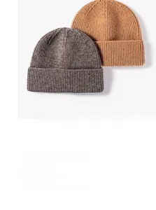 Detailed knit texture of brown and grey beanie hats with folded cuffs for autumn and winter