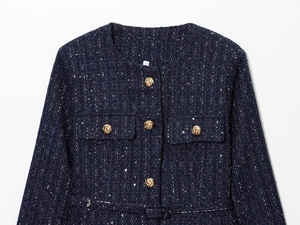 Detail einer marineblauen Tweedjacke mit Pailletten und geprägten goldenen Knöpfen