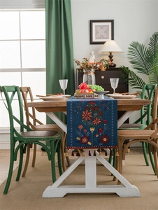 Blue embroidered table runner with floral Christmas patterns and decorative tassels
