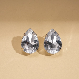 Macro shot of silver-tone pear-cut crystal stud earrings with classic four-prong setting