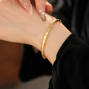 Macro shot of gold geometric arrow link bracelet on wrist with high polish finish