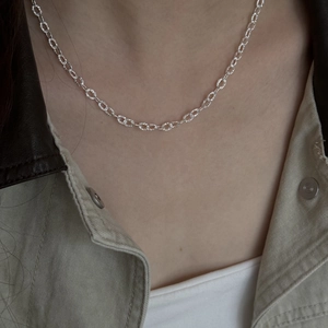 Chic silver geometric round link necklace for women worn with a stylish khaki jacket