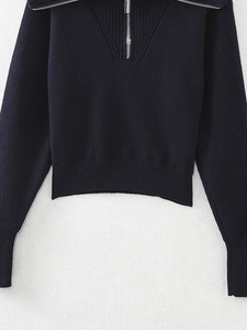 Close-up of knit texture and silver zipper detail on this casual navy sweater