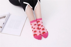 Gros plan de chaussettes en coton rose avec motifs de pommes rouges et bords contrastés