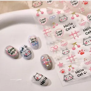 Détail de stickers à ongles chat et cerise appliqués sur de faux ongles manucurés