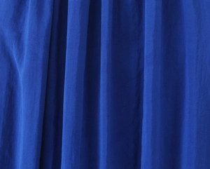 Detailed macro view of the premium blue fabric texture with vertical pleats and elegant drape