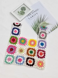 Flat lay of colorful crochet granny square tote bag with intricate floral patterns