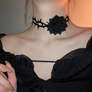 Nahaufnahme eines schwarzen Gothic-Chokers mit 3D-Rose und Dornendraht-Design am Hals