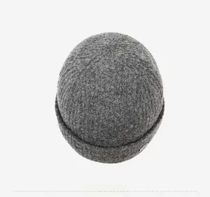 Overhead view of a dark grey knit beanie showing detailed wool texture and metal tag