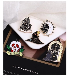 Detail of 5 enamel pins set featuring spooky motifs like skull apple and wizard hat