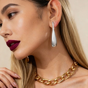 Minimalist silver water drop earrings shown on model with bold stylish metal aesthetics