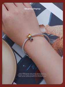 Close-up of a s925 silver mesh bracelet with a colorful enamel cartoon cow charm