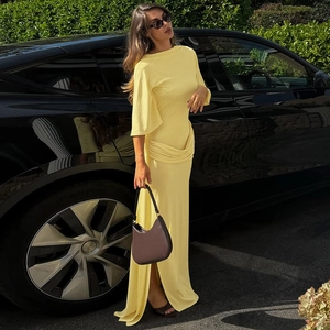 Detail of elegant yellow maxi dress featuring side slit and stylish flared sleeves