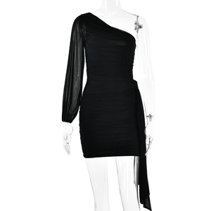 Détail de la robe noire à une épaule avec manche en résille et design en tissu froncé chic