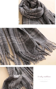 Macro detail of 100% cashmere gray plaid scarf showing soft texture and hand-tied tassels