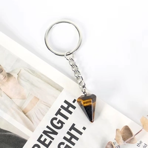 Detail of tiger eye stone keychain with hexagonal crystal pendant and silver metal ring