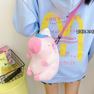 Detailed view of pink plush pig crossbody bag featuring a soft zipper and blue hat