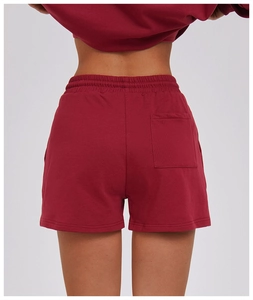 Macro view of burgundy sports shorts featuring elastic waistband and back patch pocket detail