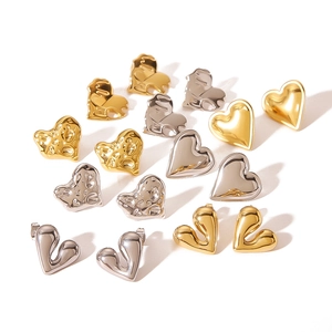 Assortment of heart-shaped stainless steel earrings in gold and silver finishes on white