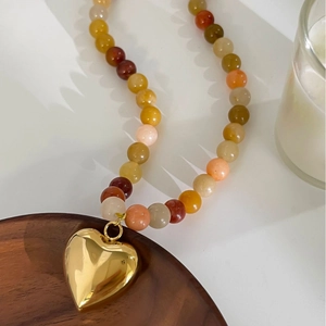 Colorful natural stone beaded necklace featuring a polished gold heart-shaped pendant