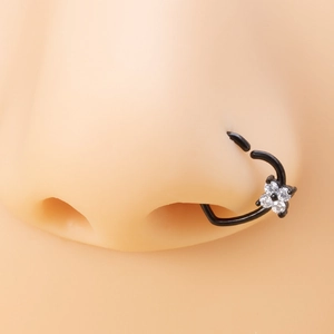 Macro view of a black heart nose ring with zircon flower on a skin-tone model