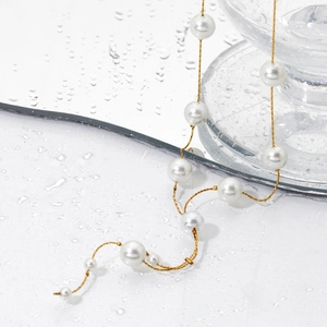 Collier élégant en forme de Y en acier inoxydable et perles sur fond blanc humide