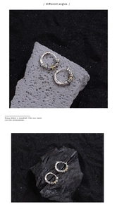 Detailed macro view of vintage two-tone hoop earrings with intricate floral engravings