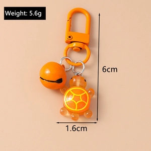 Detail view of orange resin turtle keychain with metal bell showing 6cm length and 5.6g weight