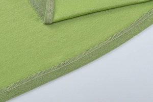 Detailed close-up of bright green knitted fabric with metallic luster and fine stitching