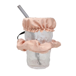 Pink scrunchie drink cover set with silver glitter dots on a textured glass cup