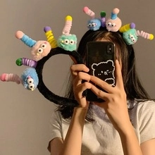 Close-up of colorful plush monster headband with funny cartoon eyes and spring antennae