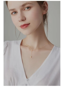 Nahaufnahme der minimalistischen S925 Silber Goldperlenkette am Hals mit weichem Licht