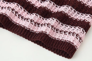 Close-up of pink and maroon striped knit fabric showing detailed crochet texture and patterns
