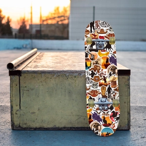Detail of Western cowboy stickers on a skateboard featuring hats and boots in sunset light