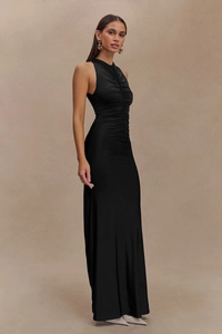Detailed close-up showing the elegant side pleats and ruched texture on the black dress