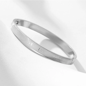 Detail view of silver titanium steel bangle with LOVE engraving and clasp closure