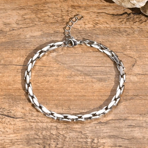 Close-up of flat stainless steel chain bracelet with lobster clasp on wooden background