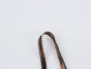 Close-up of black mesh strap with sparkling clear rhinestones on leopard print dress