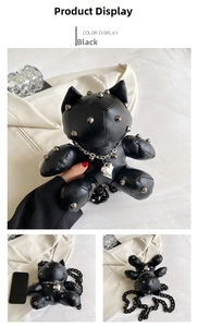 Close-up of black cat doll bag with silver rivets and heart pendant necklace detail