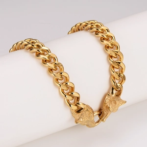 Polished gold stainless steel viking wolf head chain necklace displayed on white pillar